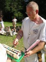 Milan Naď na táboře 2004 jako Praotec Medvěd krájí dort pro vítězný oddíl